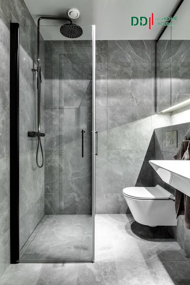Nhà vệ sinh hiện đại với phòng tắm đứng được bao quanh bằng kính trong suốt.